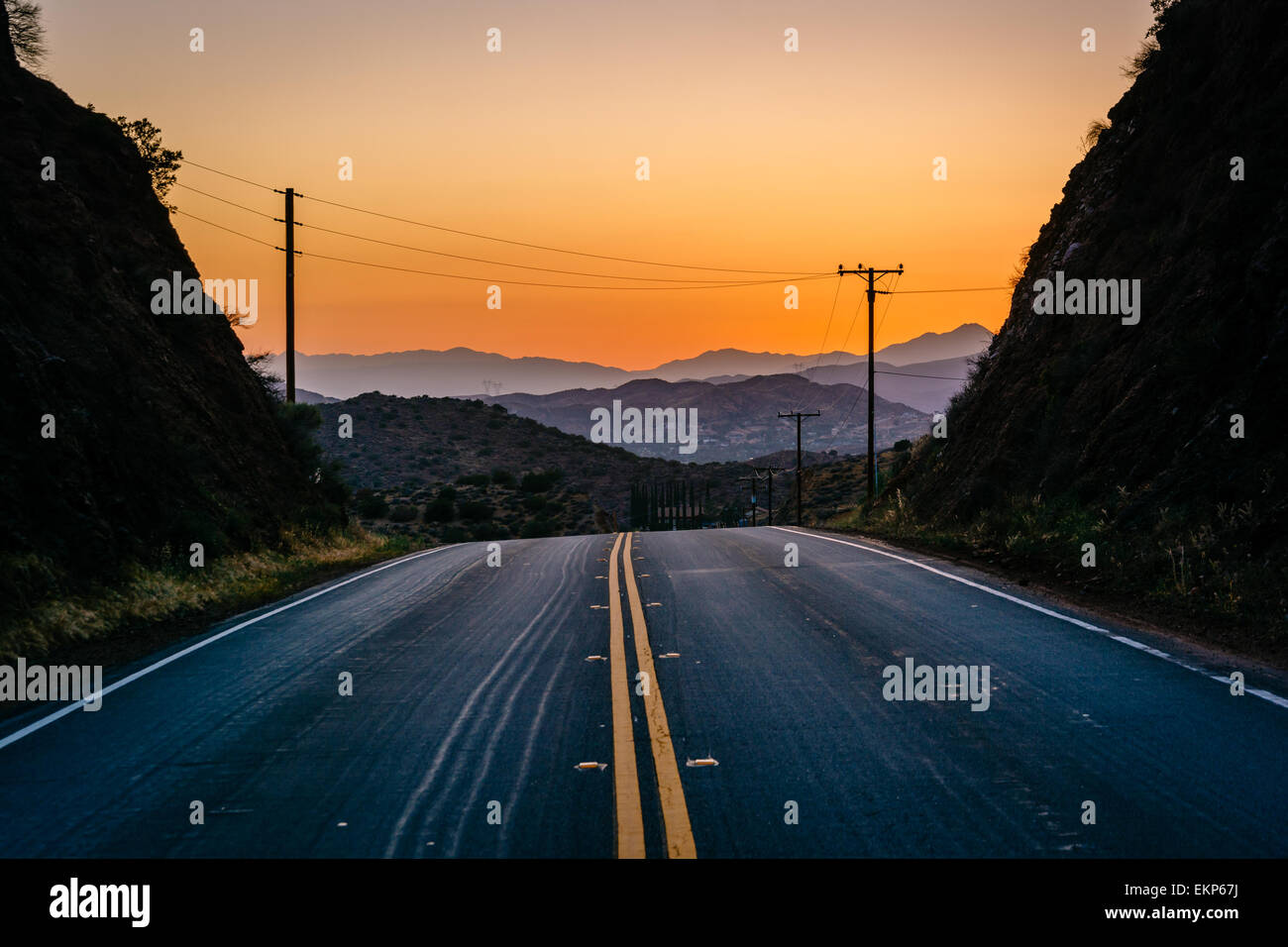 Sunset over distant mountains and Escondido Canyon Road, in Agua Dulce, California. Stock Photo