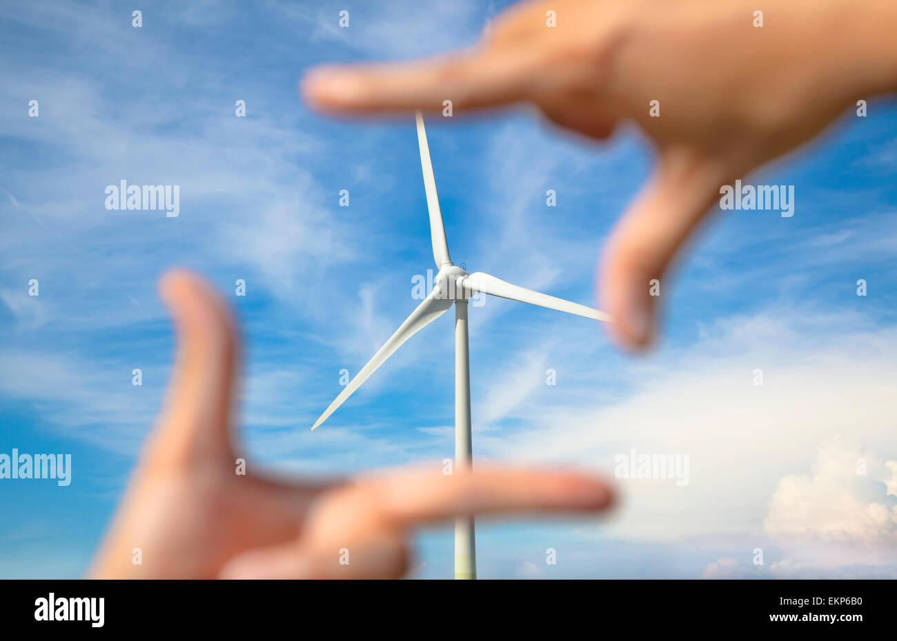 looking at windmill power generator with hand frame Stock Photo