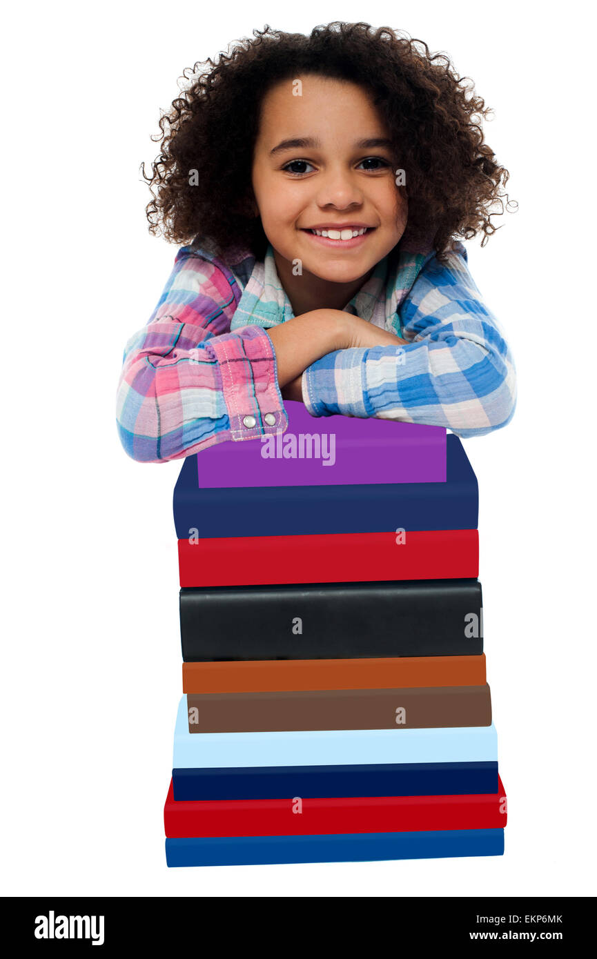 Smart little girl leaning over pile of books Stock Photo - Alamy