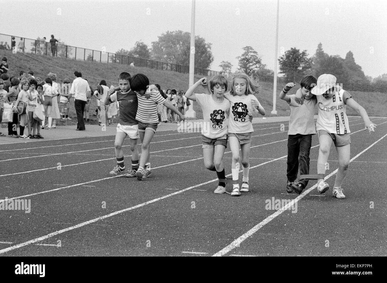 Boys and girls tied together as they take part in the Three Legged race at their school sports day. 20th June 1979. Stock Photo