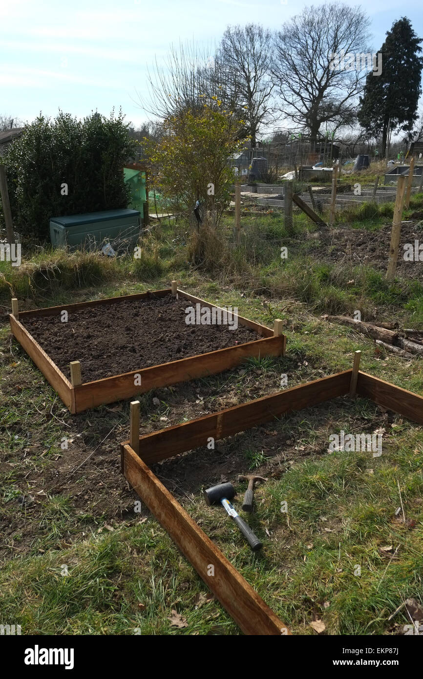 DIY raised beds, made from timber gravel boards, being constructed on