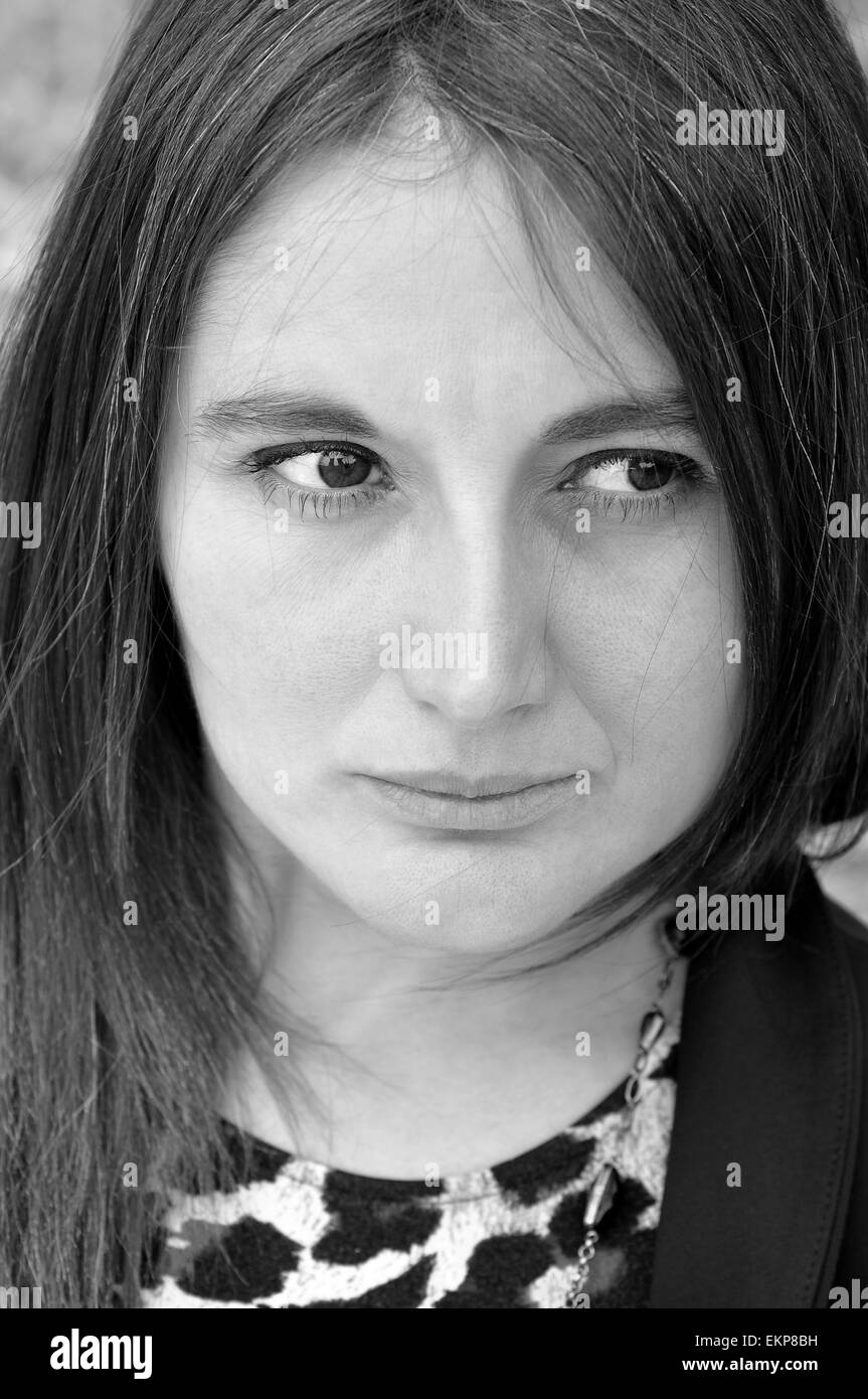 Young woman sadly looking with expression of melancholy eyes. Stock Photo