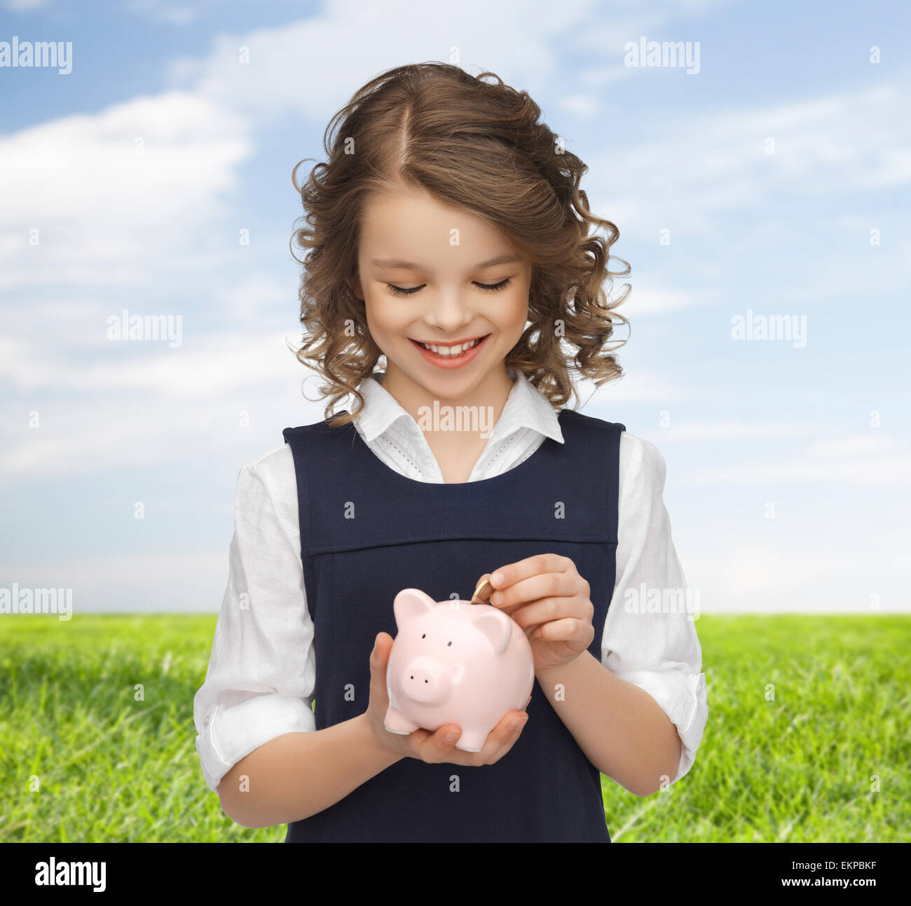 happy girl putting coin into piggy bank Stock Photo - Alamy