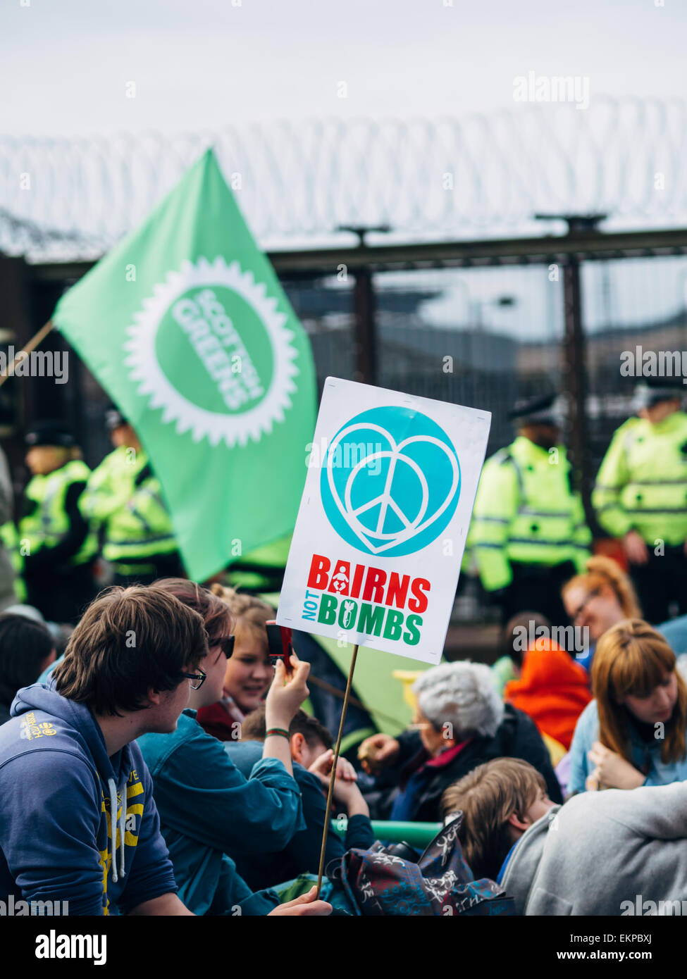 Glasgow, UK. 13th April, 2015. Protestors of all ages gather at Faslane Naval base in Glasgow to capmpaign against the Trident nuclear submarines based there, with the slogans 'Scrap Trident' & #BairnsNotBombs. Credit:  Alan Robertson/Alamy Live News Stock Photo