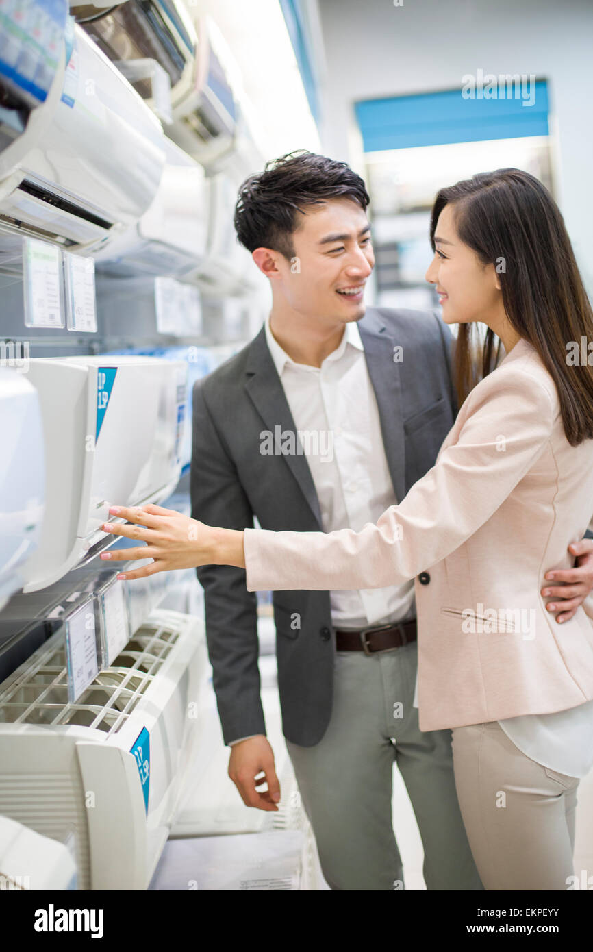 Young couple buying air conditioner in electronics store Stock Photo