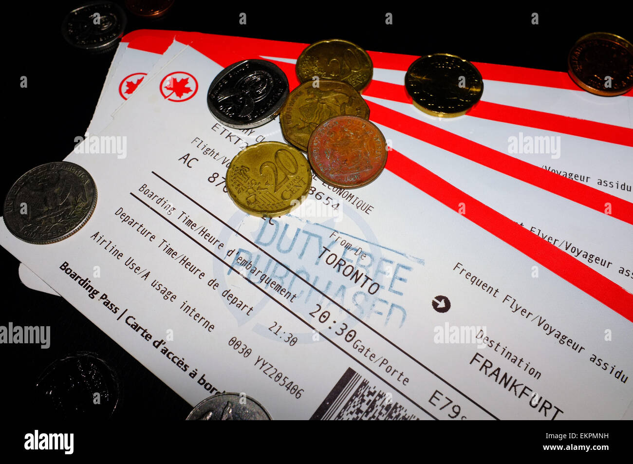 Coins on top of set of Air Canada tickets from Toronto to Johannesburg via Frankfurt Airport. Stock Photo
