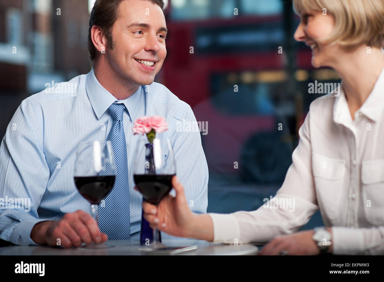 Happy couple drinking red wine at a restaurant Stock Photo - Alamy