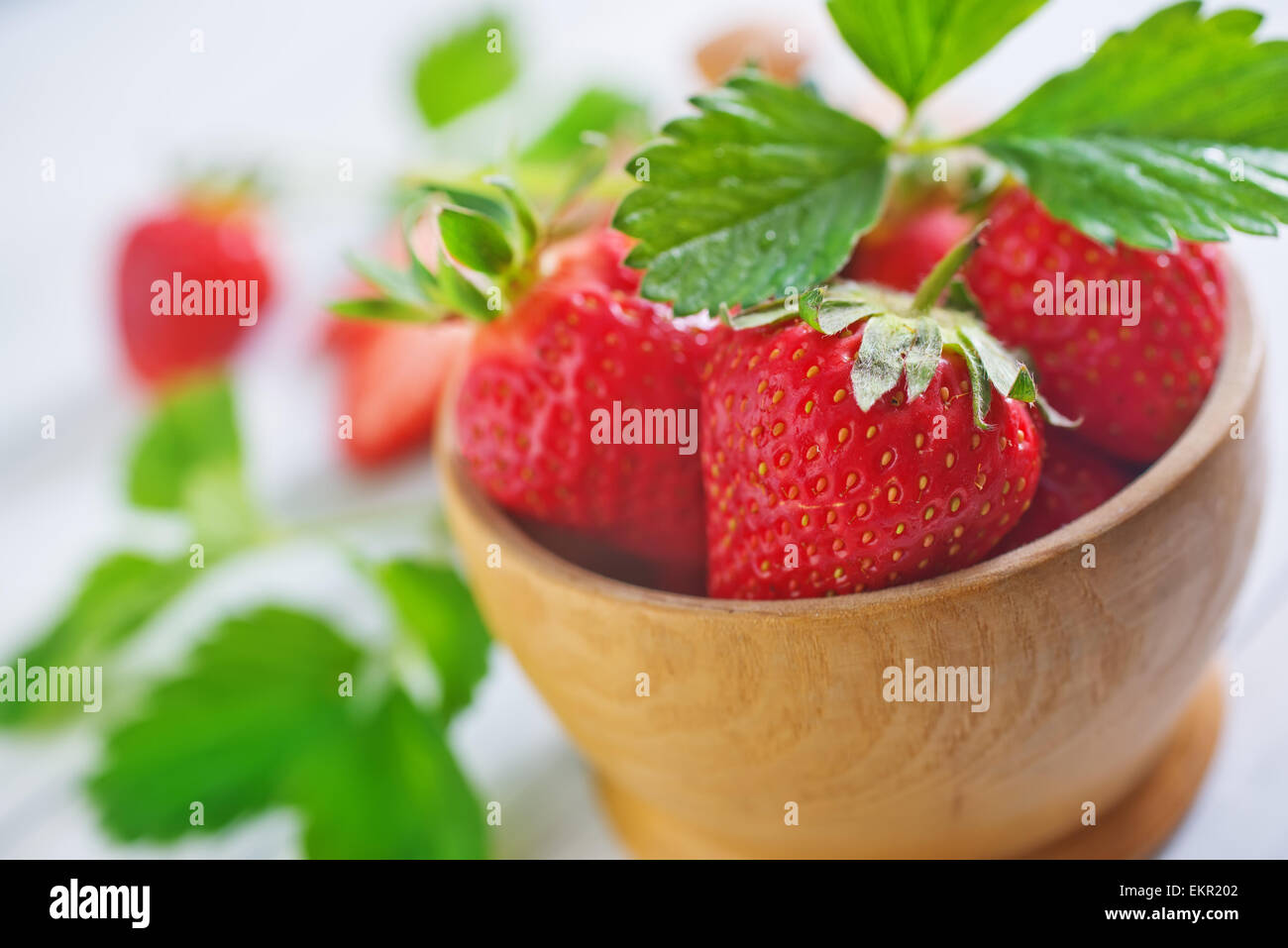 strawberry in wooden bowl and on a table Stock Photo - Alamy