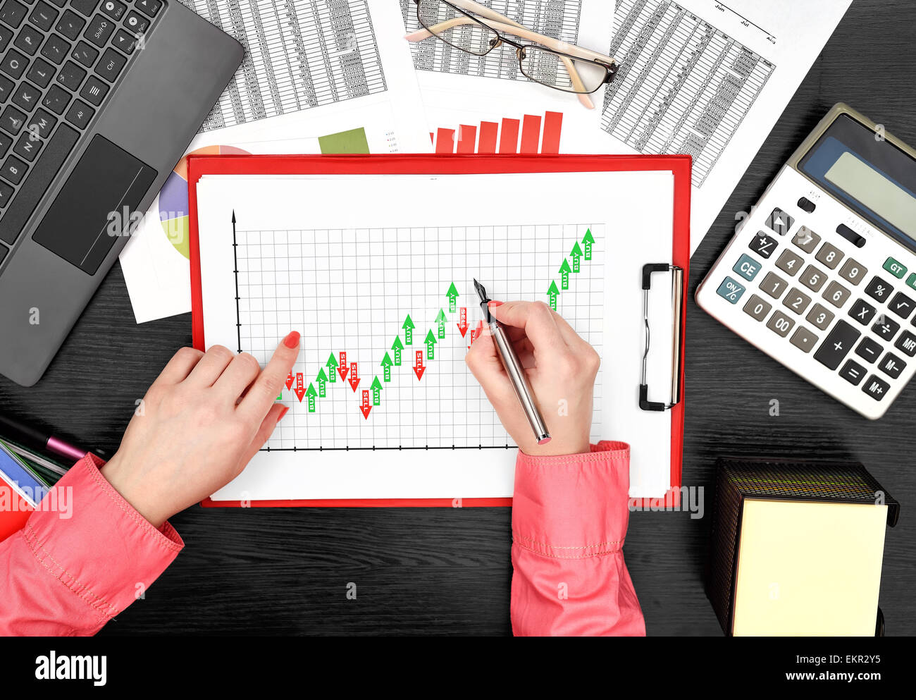 Woman Drawing Forex Chart On Clipboard Sitting In Office Stock Photo - 