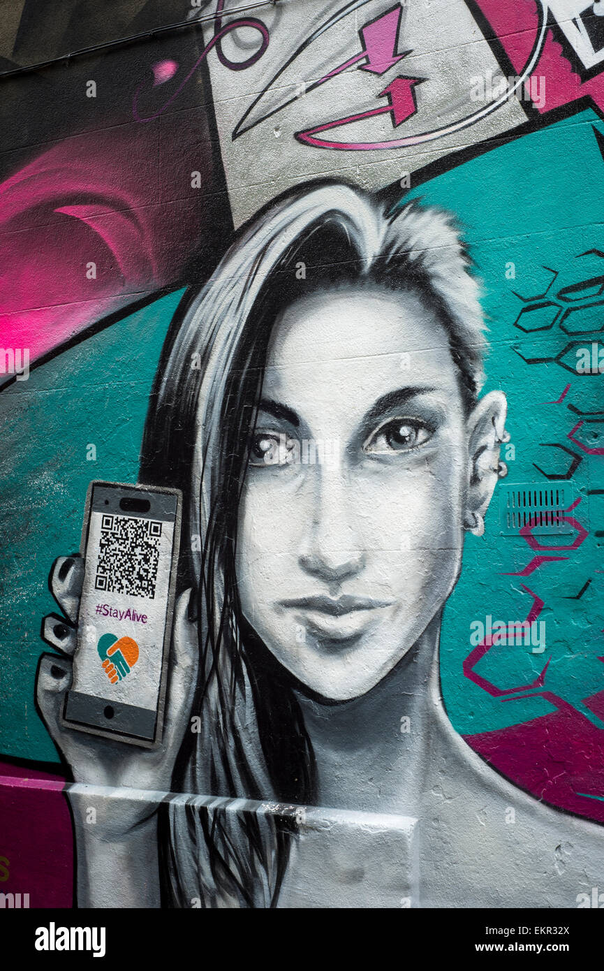 graffiti on a wall in Brighton of a woman holding a phone Stock Photo