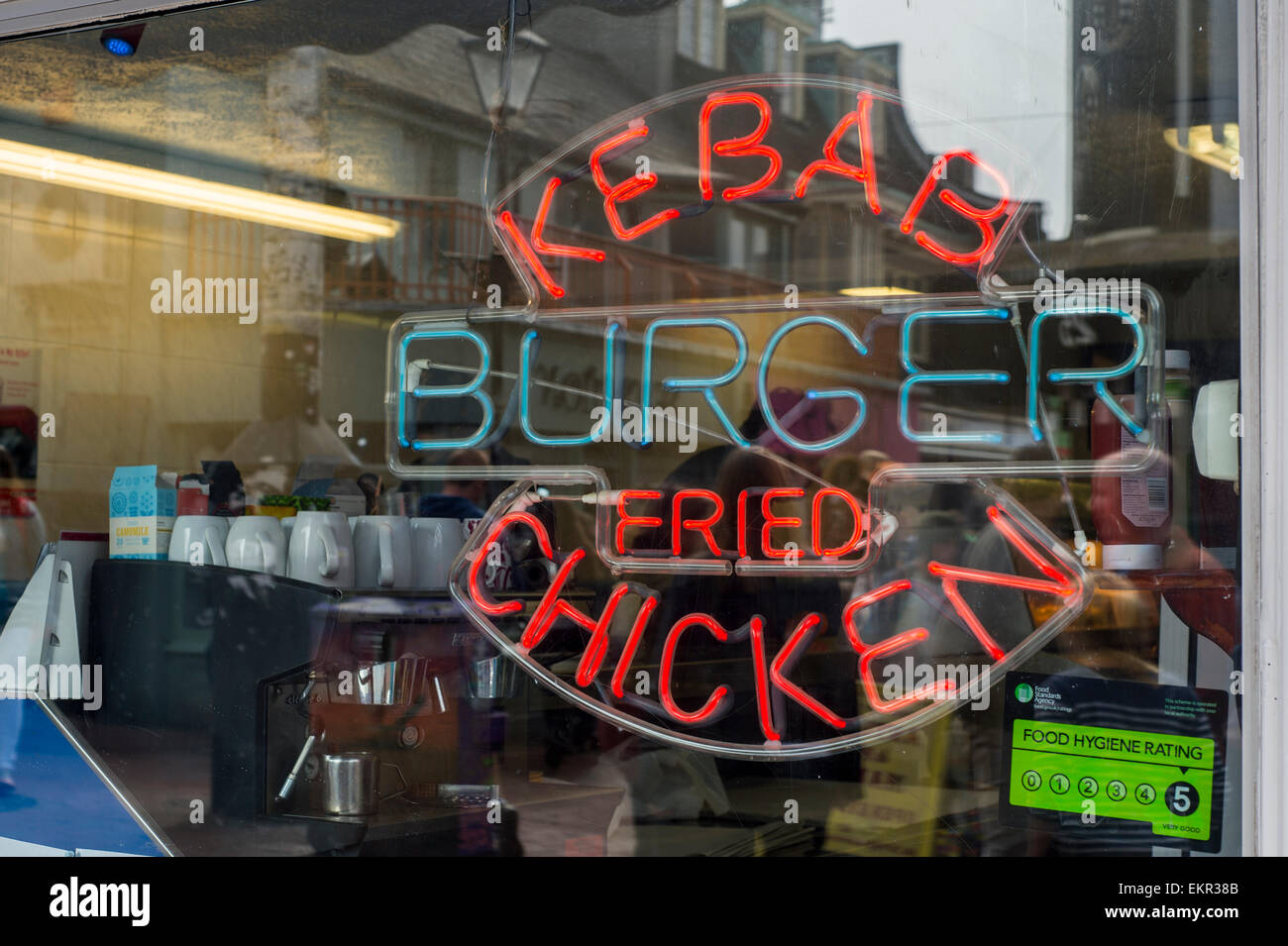 Neon kebab, burger, fried chicken sign in the window of a fast food restaurant in Brighton Stock Photo
