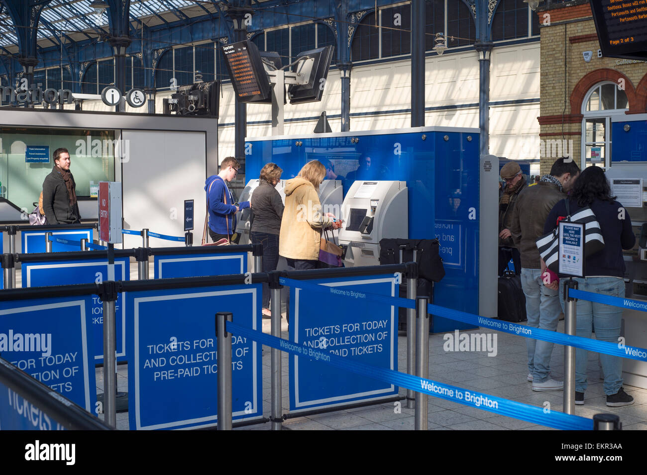 Train commuters using the self service ticket machines at Brighton Station Stock Photo