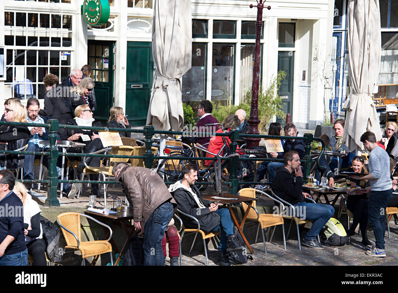Tourists relax in outdoor canal-side cafe,  Amsterdam, Holland Stock Photo