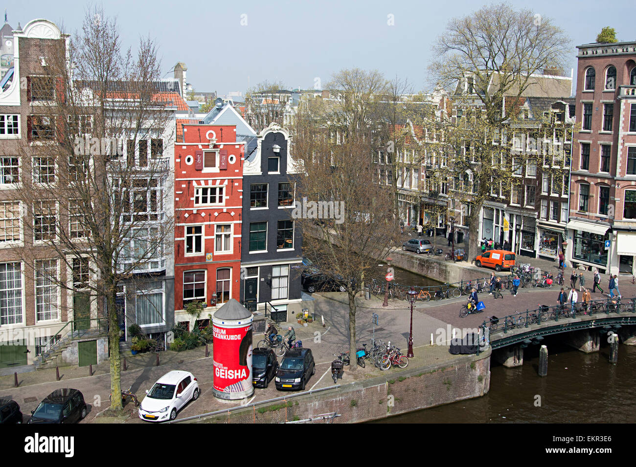 Lovely canal-side scene with unique tall narrow houses overlooking canals and bridge in Amsterdam. Stock Photo