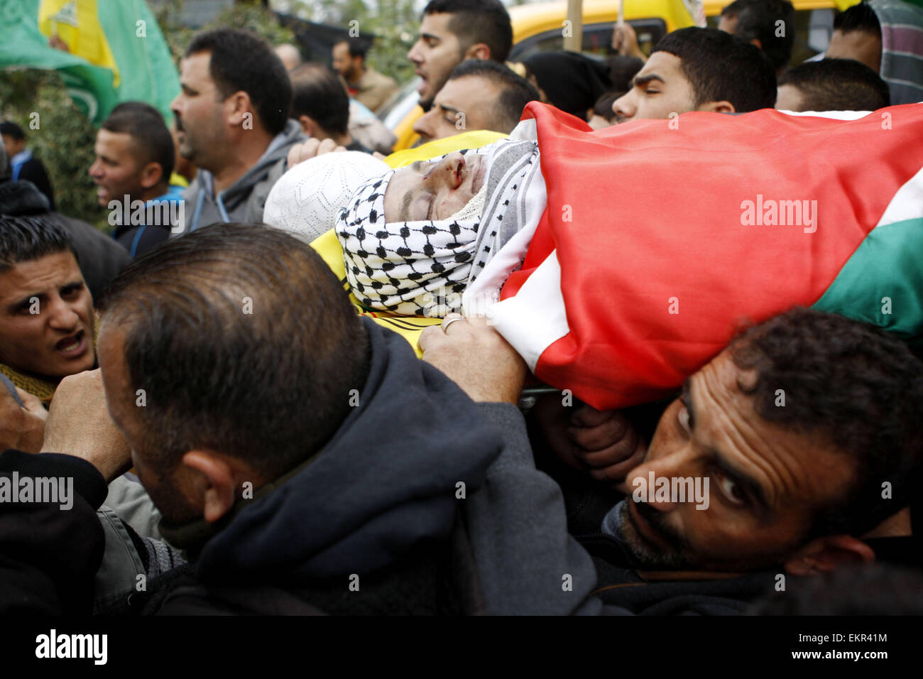 Sinjil, West Bank. 13th Apr, 2015. Mourners carry the body of 27-year-old Palestinian MOHAMMED JASSER KARAKRA, during his funeral in Sinjil village. Karakra stabbed two Israeli soldiers in the northern West Bank on April 8, 2015, wounding one seriously before being shot dead. It was the second knife attack in a week targeting Israeli soldiers and the latest in a wave of lone-wolf attacks which have been on the rise since last summer's 50-day war in the Gaza Strip. © Shadi Hatem/APA Images/ZUMA Wire/Alamy Live News Stock Photo