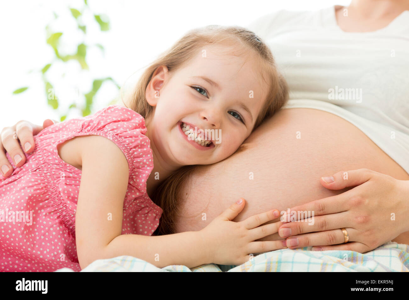 happy kid girl hugging pregnant mother Stock Photo