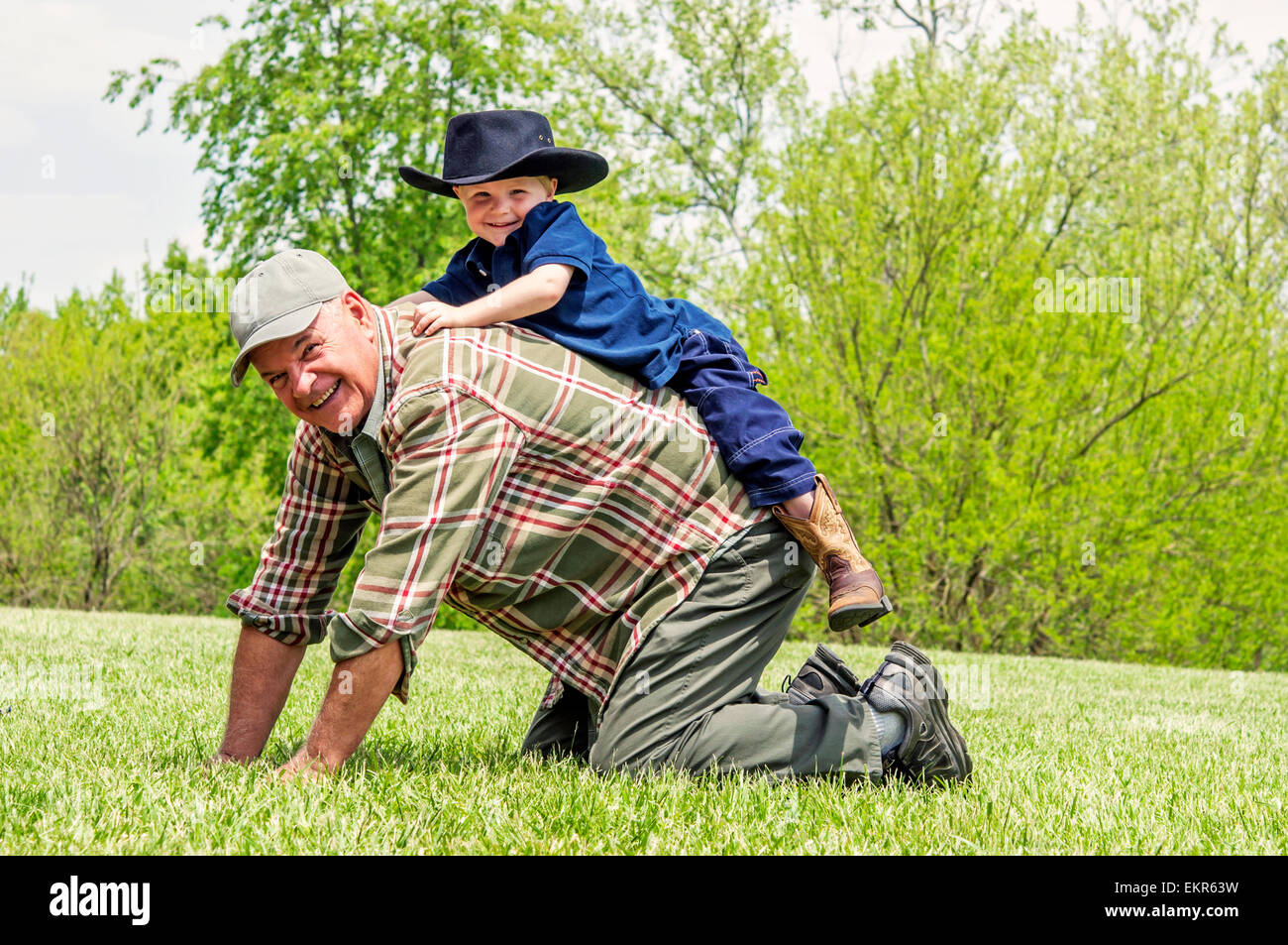 boy playing on Grandfather's back Stock Photo