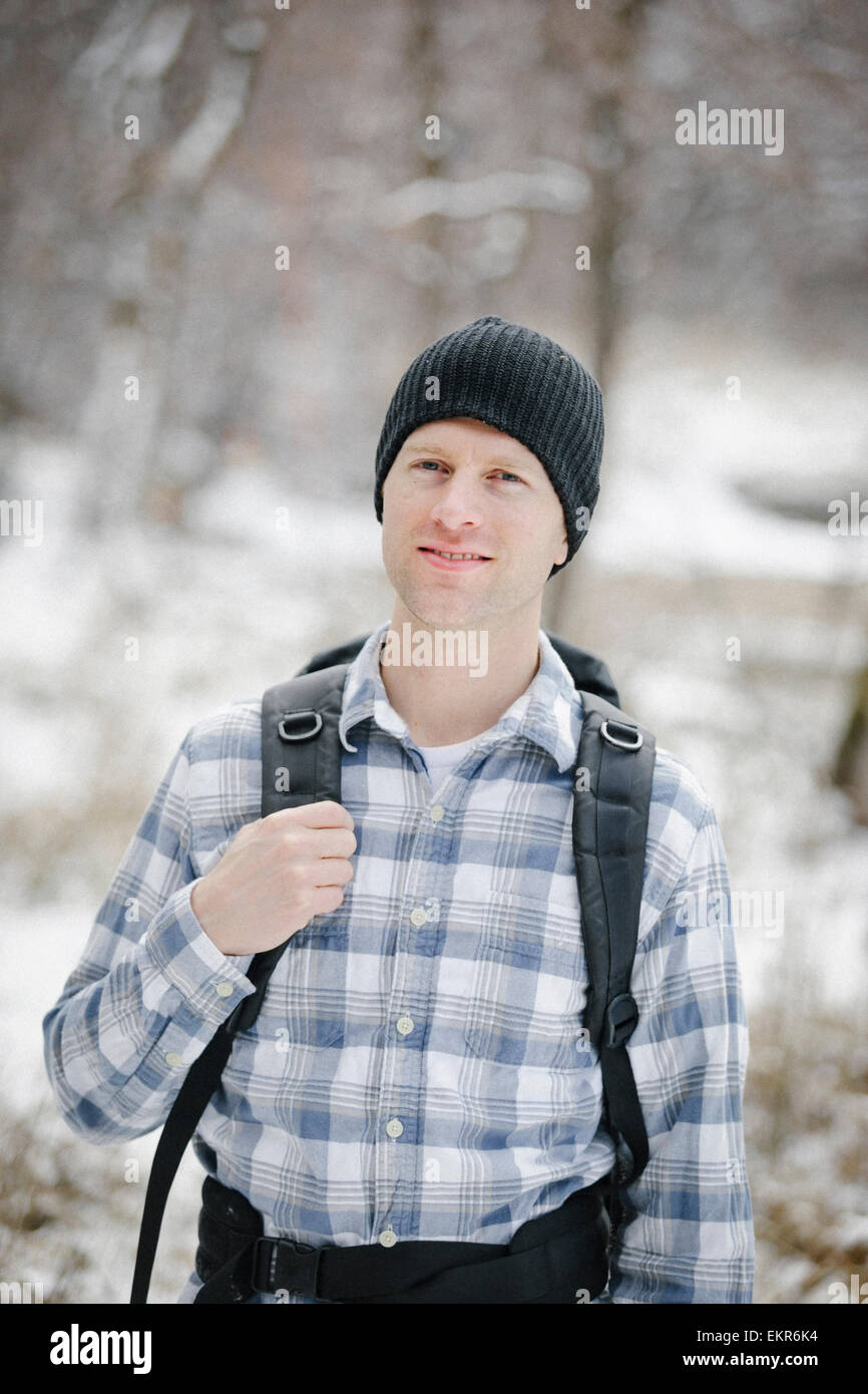 A hiker in the mountains with a rucksack and a woolly hat. Stock Photo