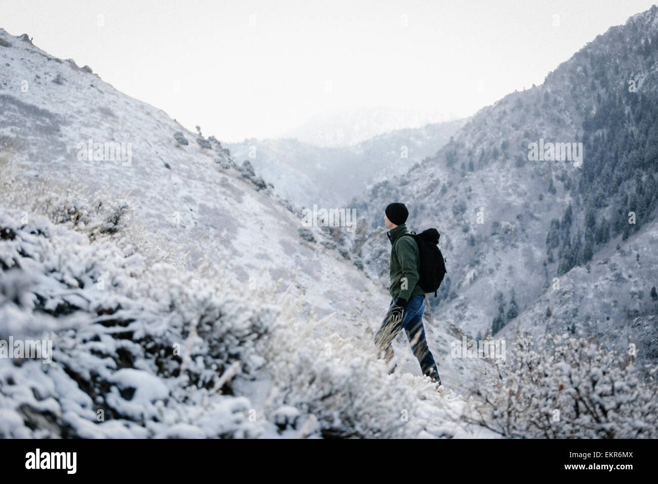 A man hiking through the mountains carrying a rucksack. Stock Photo