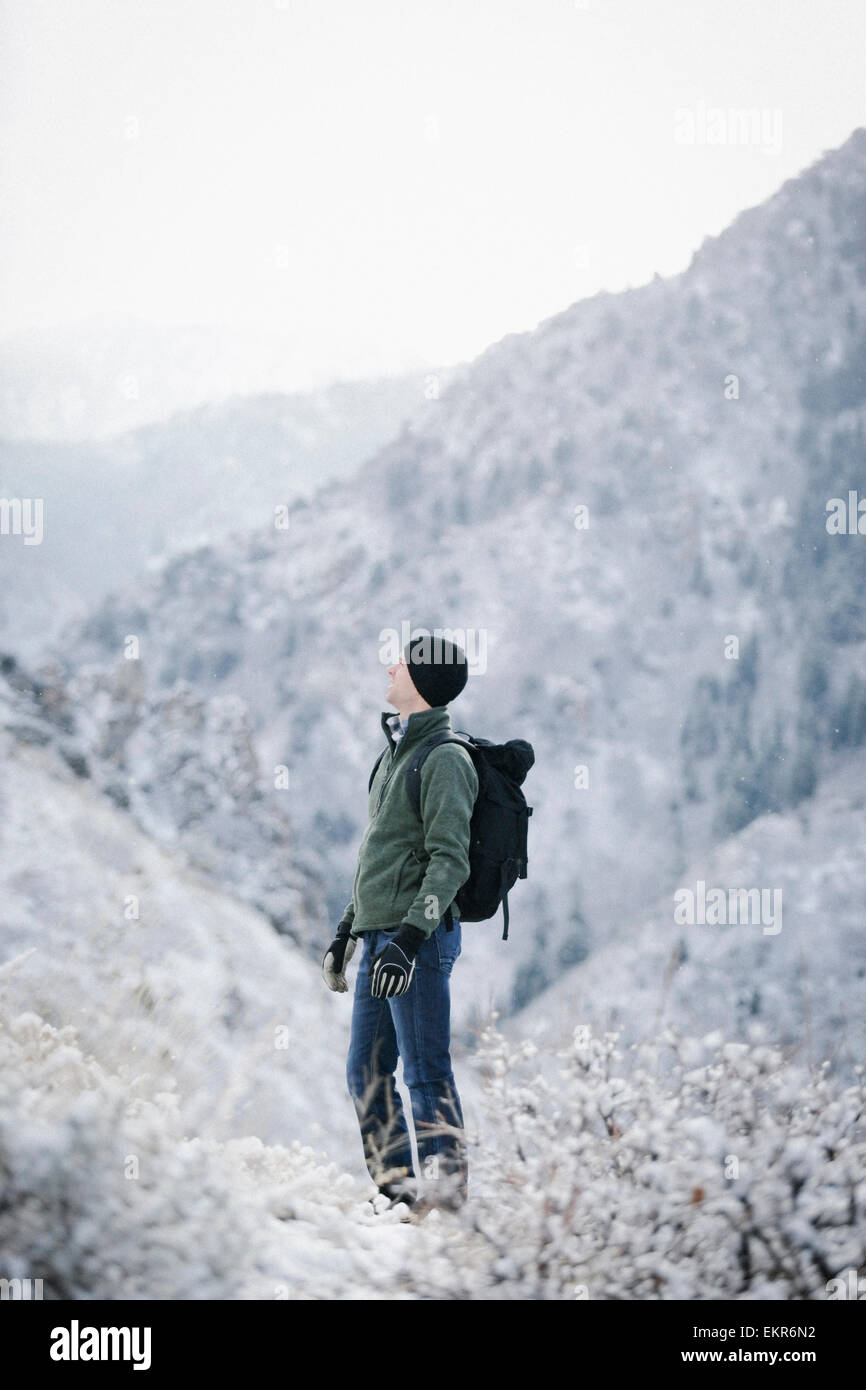 A man hiking through the mountains carrying a rucksack. Stock Photo