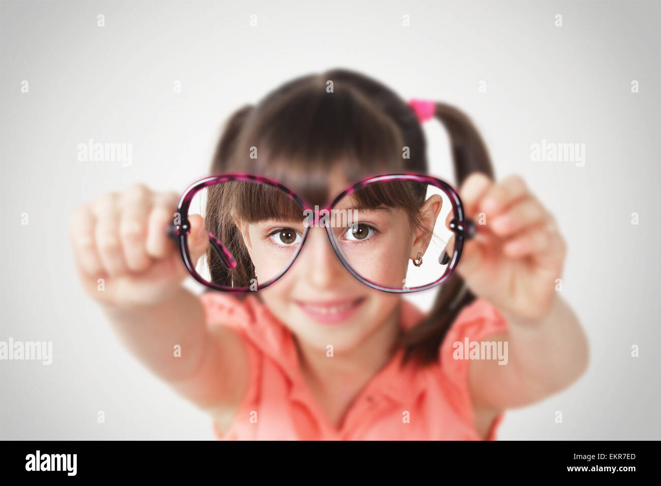 little girl holding eyeglasses, health eyesight concept. Soft focus Stock Photo