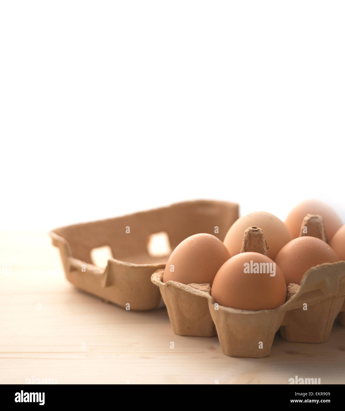 6 hen eggs in a carton box. Gradiant from wood to white free space for text, blur effect. Stock Photo