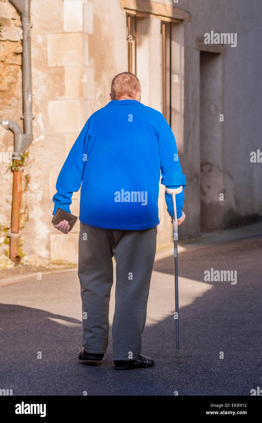 Back view of man walking with caliper stick - France. Stock Photo
