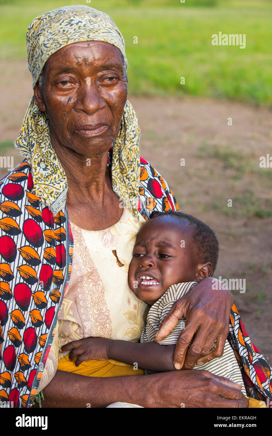 In mid January 2015, a three day period of excessive rain brought unprecedneted floods to the small poor African country of Malawi. It displaced nearly quarter of a million people, devastated 64,000 hectares of alnd, and killed several hundred people. This shot shows a displaced grand mother and child in the refugee camp of Chiteskesa refugee camp, near Mulanje. Stock Photo