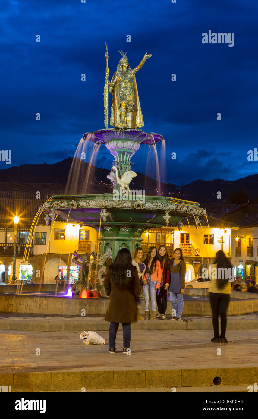 Peru, Cusco. Plaza de Armas at Night. Young Women Taking Photos Stock