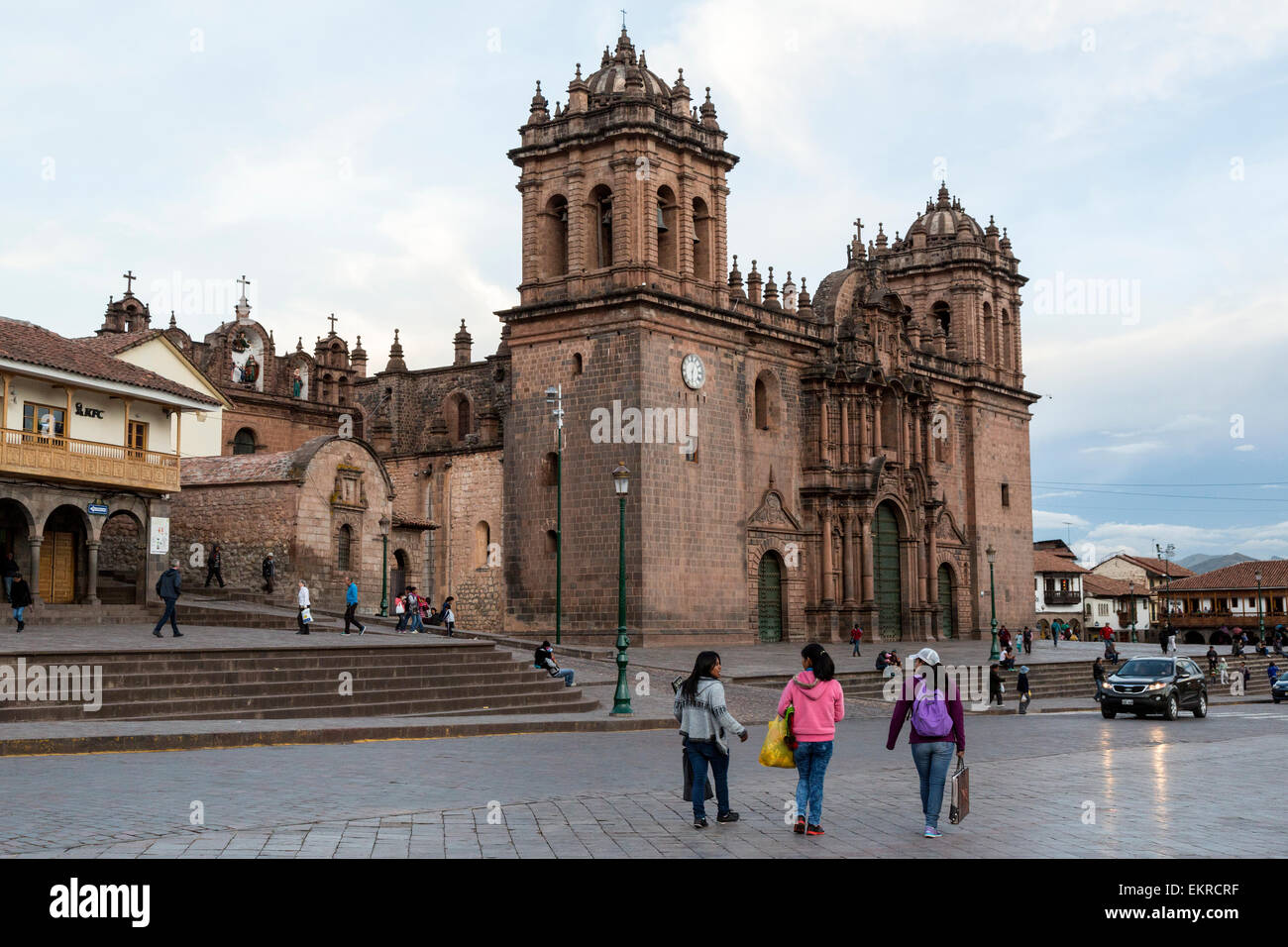 Peru, Cusco.  Young Women Walking in the Plaza de Armas; Cathedral in Background. Stock Photo
