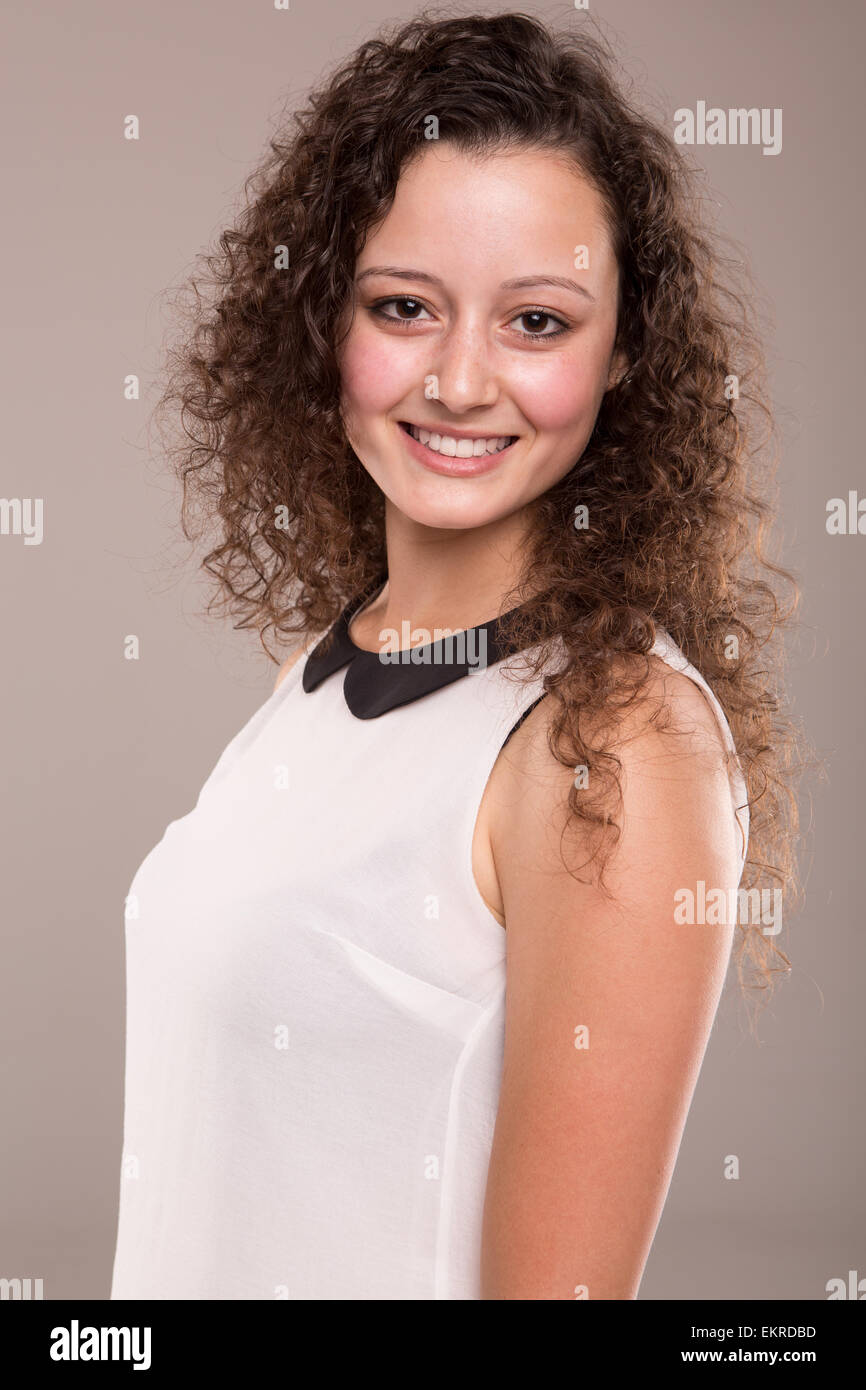 Beautiful young woman with curly hair posing Stock Photo - Alamy