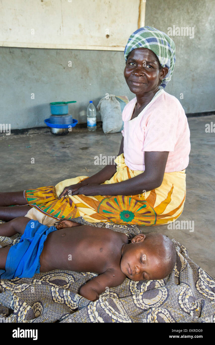In mid January 2015, a three day period of excessive rain brought unprecedented floods to the small poor African country of Malawi. It displaced nearly quarter of a million people, devastated 64,000 hectares of land, and killed several hundred people. This shot shows a toddler and grand mother in a refugee camp near Chikwawa. Stock Photo