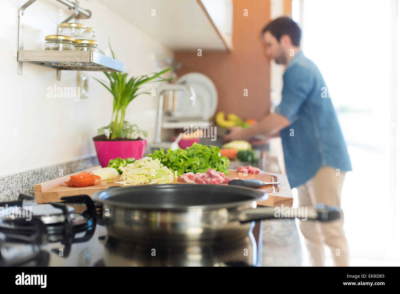 Man in kitchen cooking lunch - Focus on food Stock Photo - Alamy