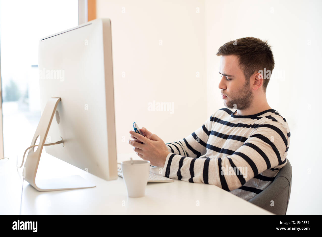 Man working and using mobile phone at the office Stock Photo - Alamy
