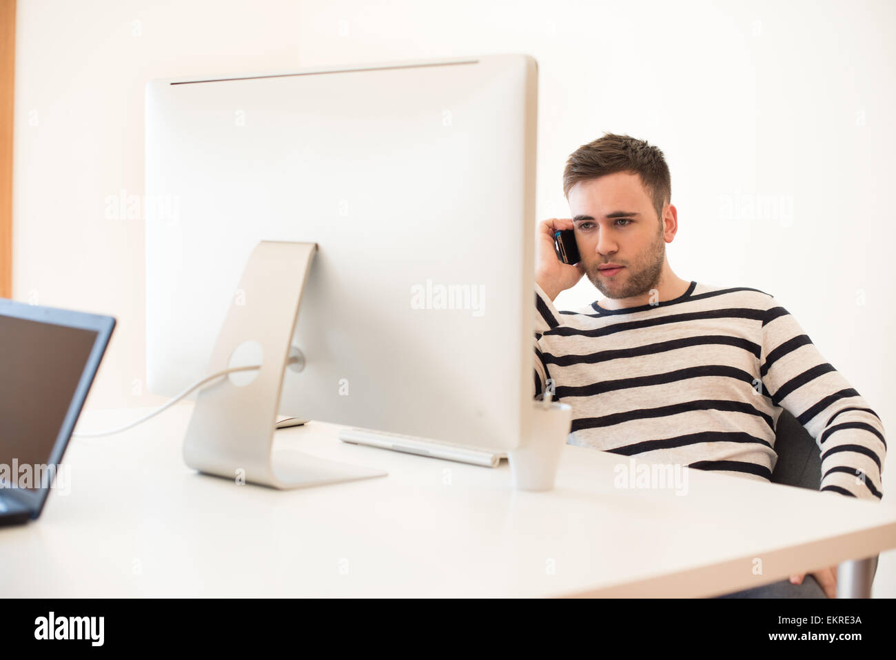 Man working and using mobile phone at the office Stock Photo - Alamy
