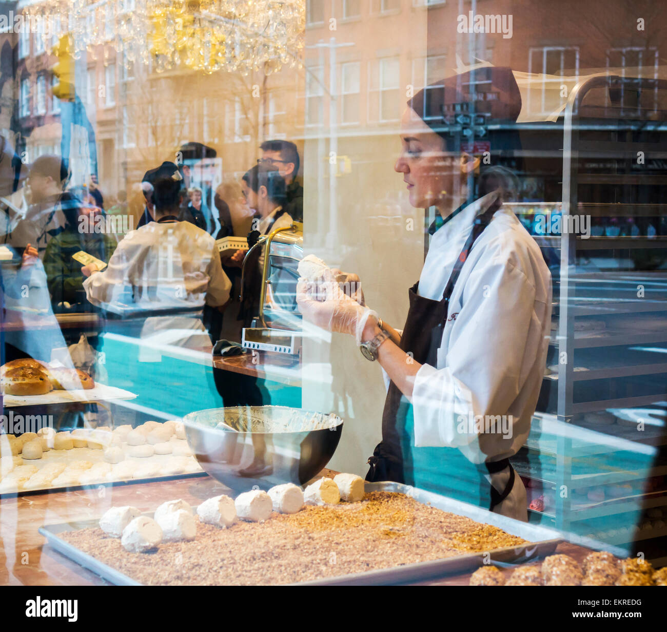 A pastry worker prepares merveilleux (wonderfuls) in the window of Aux Merveilleux du Fred in Greenwich Village in New York on Sunday, April 5, 2015. Merveilleux are confections made of two meringues stuck together with whipped cream, then coated with whipped cream and then coated with chocolate or other flavors. (© Richard B. Levine) Stock Photo