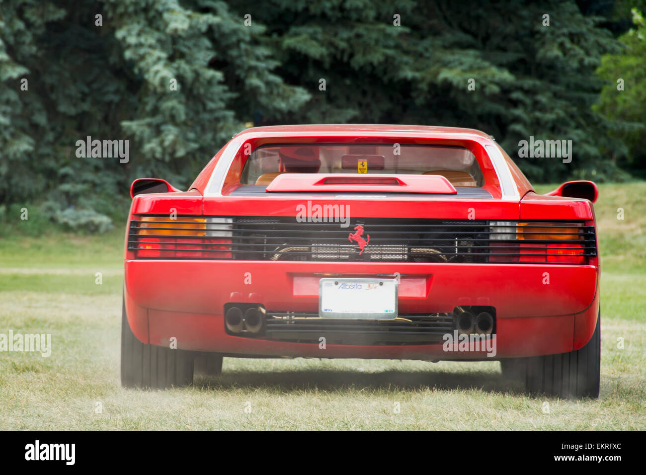 Red Ferrari Testarossa seen from the rear with exhaust fumes; Calgary, Alberta, Canada Stock Photo