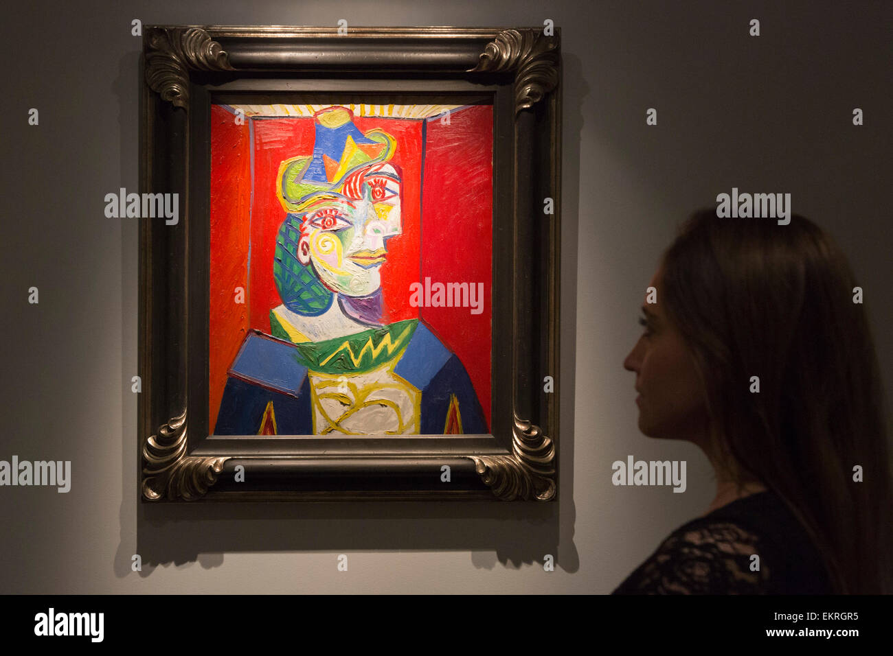 London, UK. 13 April 2015. A Christie's employee looks at the painting Pablo Picasso (1881-1973), Femme à la résille, 1938 (estimate in the region of US-$55 million). Christie's showcases a selection of almost fifty works from the spring sales in May in New York of Impressionist, Modern, Post-War And Contemporary Art. Most works will be on view to the public until 15 April at Christie’s King Street, London. Photo: ukartpics/Alamy Live News Stock Photo