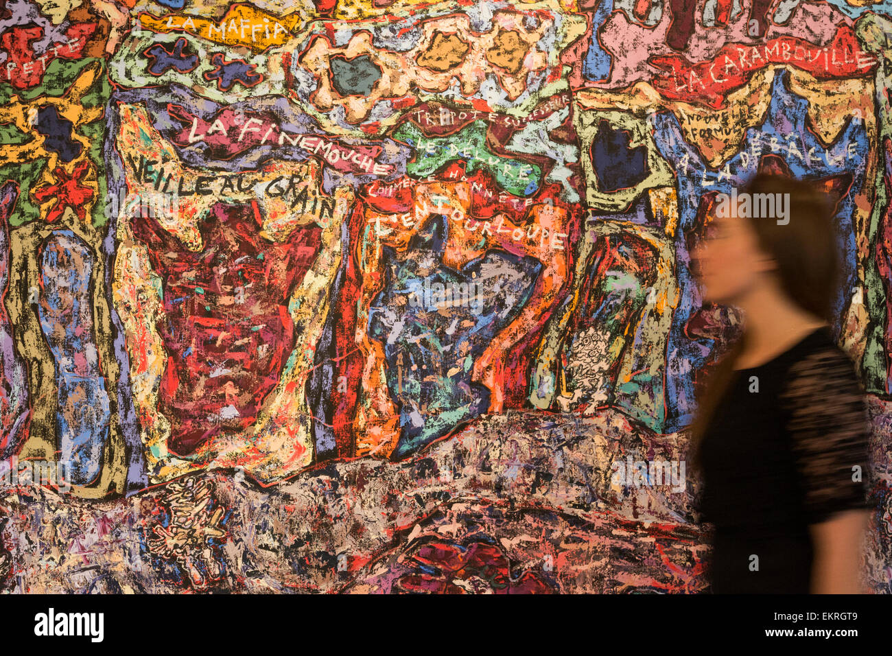 London, UK. 13 April 2015. A Christie's employee walks past the Jean  Dubuffet painting Paris Polka, 1961 (estimate in the region of $25  million). Christie's showcases a selection of almost fifty works