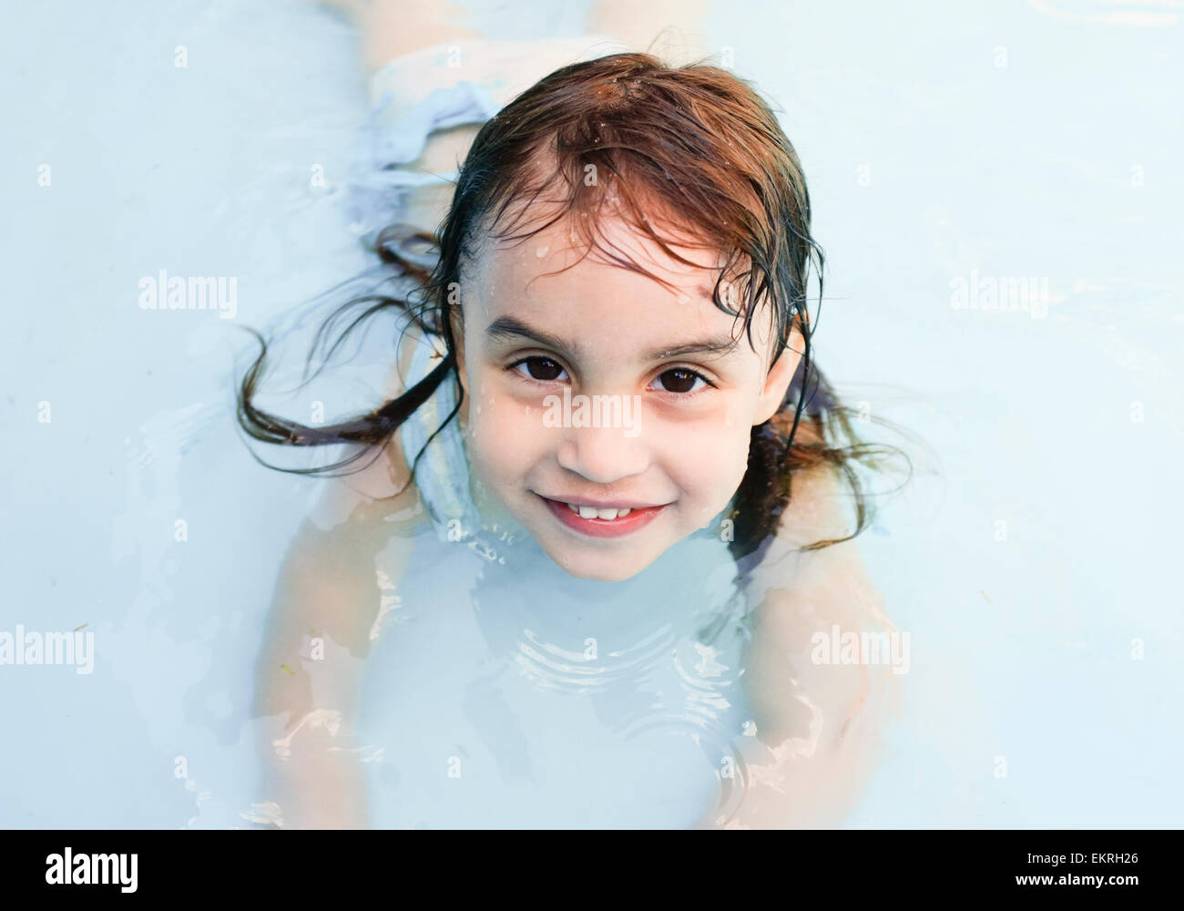 Portrait of a sweet cute female child in a swimming pool Stock Photo