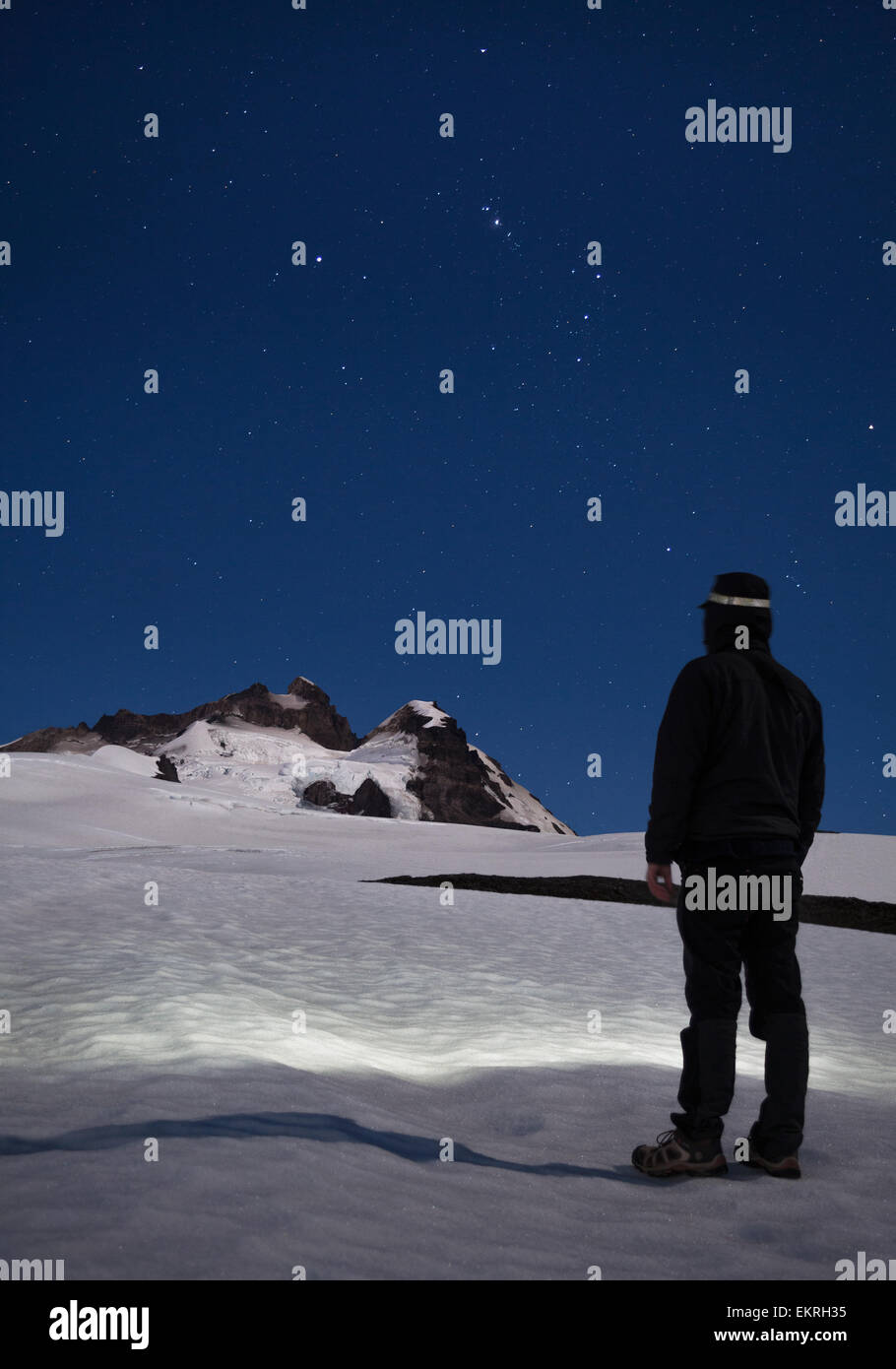 Hiker man watching and contemplating the stars and mountains at night Stock Photo