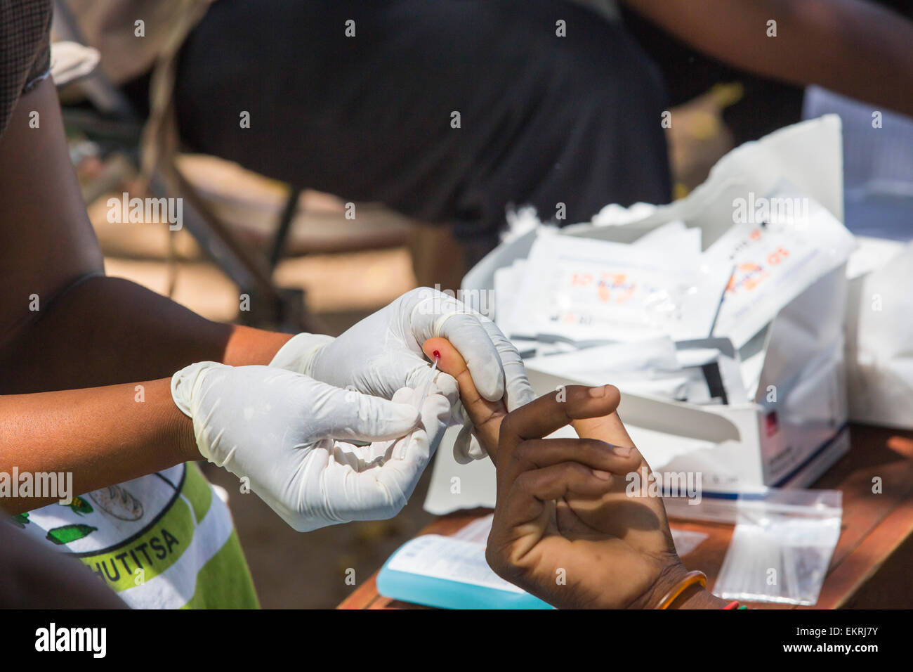 In mid January 2015, a three day period of excessive rain brought unprecedented floods to the small poor African country of Malawi. It displaced nearly quarter of a million people, devastated 64,000 hectares of land, and killed several hundred people. This shot shows A Medicin Sans Frontieres clinic in Makhanga blood testing local people for malaria, many proving positive for the disease as a result of the drying up flood waters providing ideal breeding grounds for mosquitoes. Stock Photo