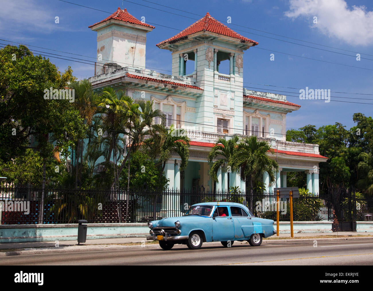 A classic american retro car passes a colonial style villa in Havana Stock Photo