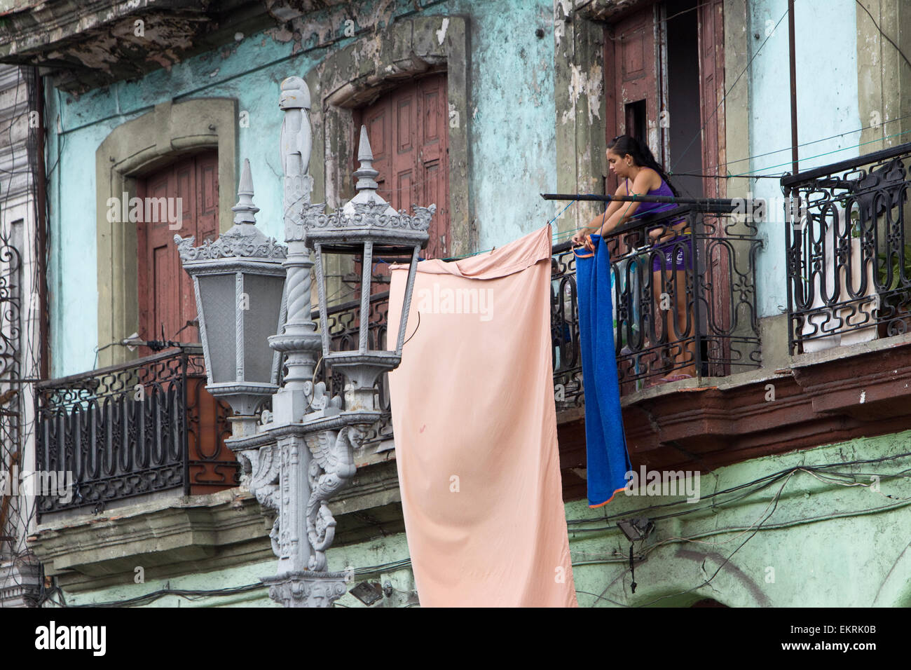 Woman in Havana,Cuba,hanging up her washing on the balcony opposite the Capitolio building Stock Photo