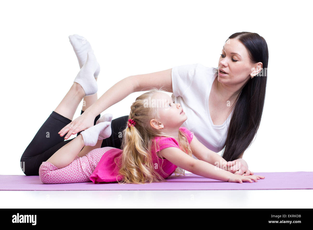 mother teaches kid girl exercising showing by example Stock Photo