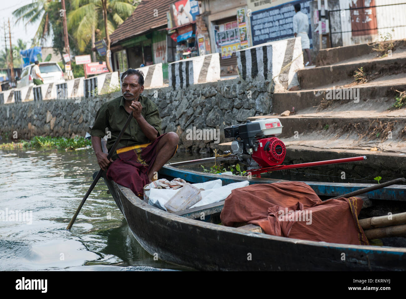 A man in a motor boat on the Backwaters of Kumarakom, Kerala India Stock Photo
