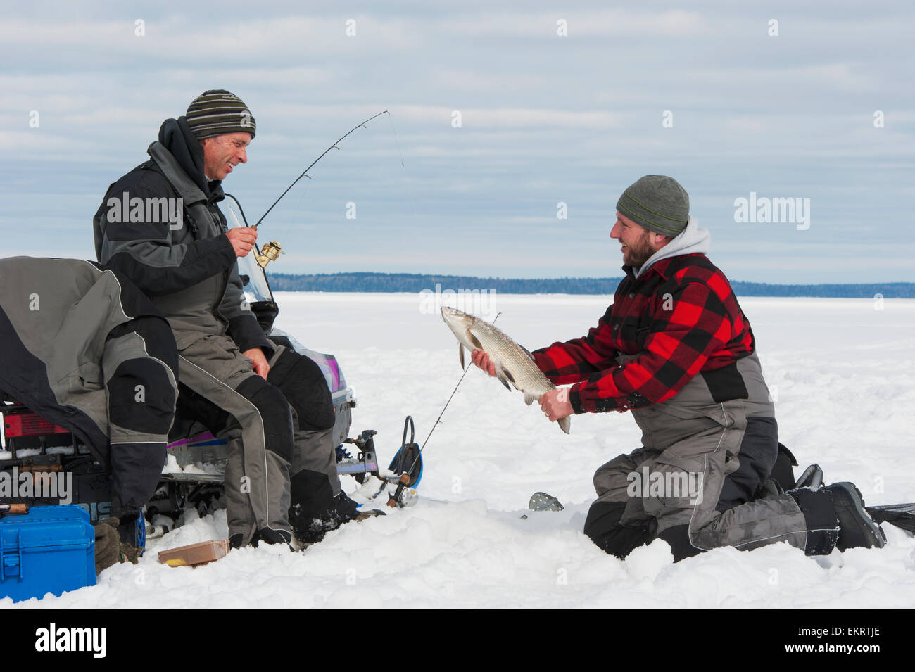 Two ice fishermen, one holding a large whitefish; Ontario, Canada Stock