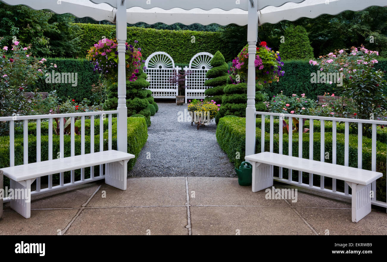 White gazebo with hanging flower baskets in Minter Gardens; Rosedale, British Columbia, Canada