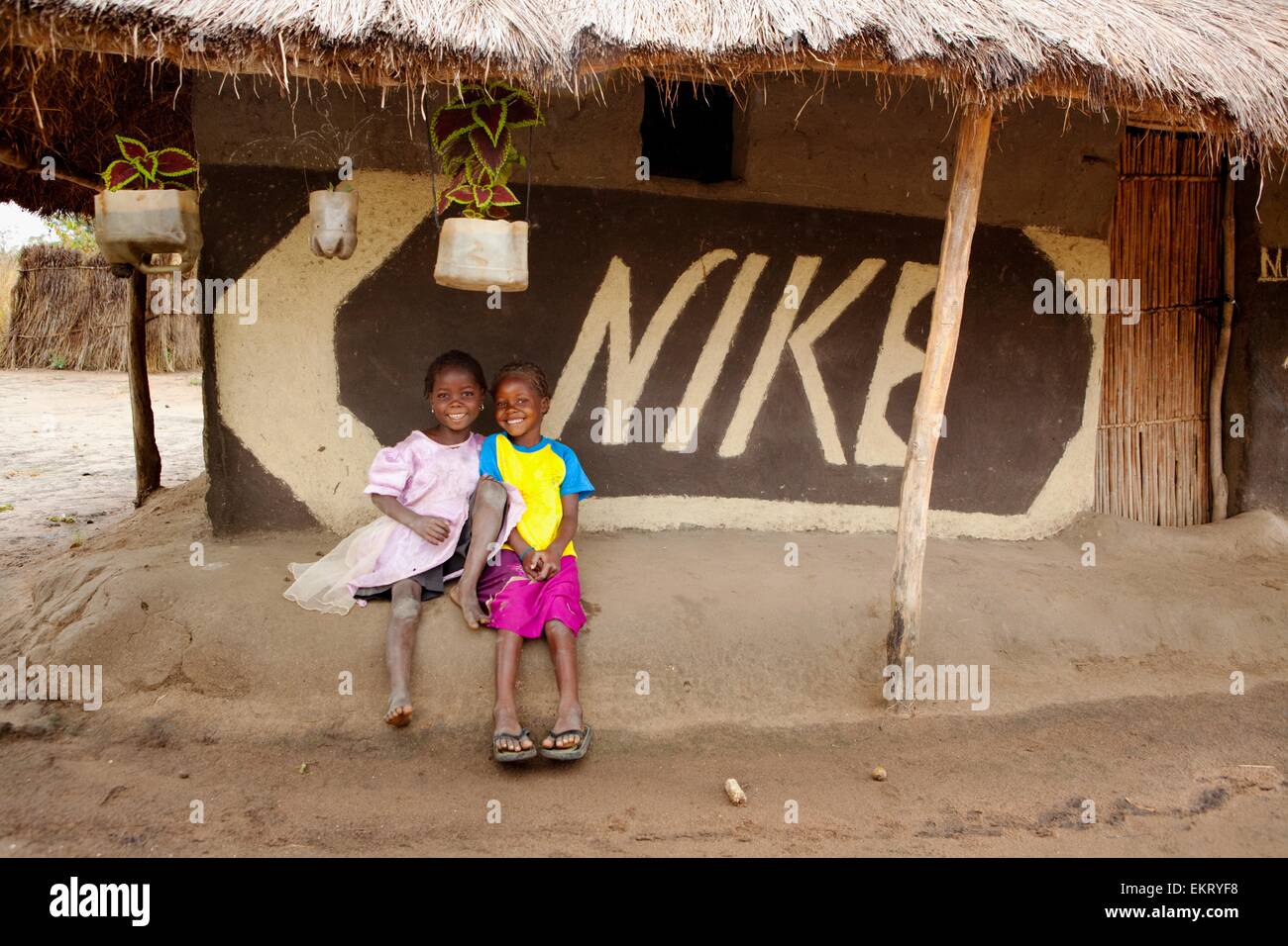 Two Children Sit Beside A Hand Painted Nike Sign; Manica, Mozambique, Africa  Stock Photo - Alamy