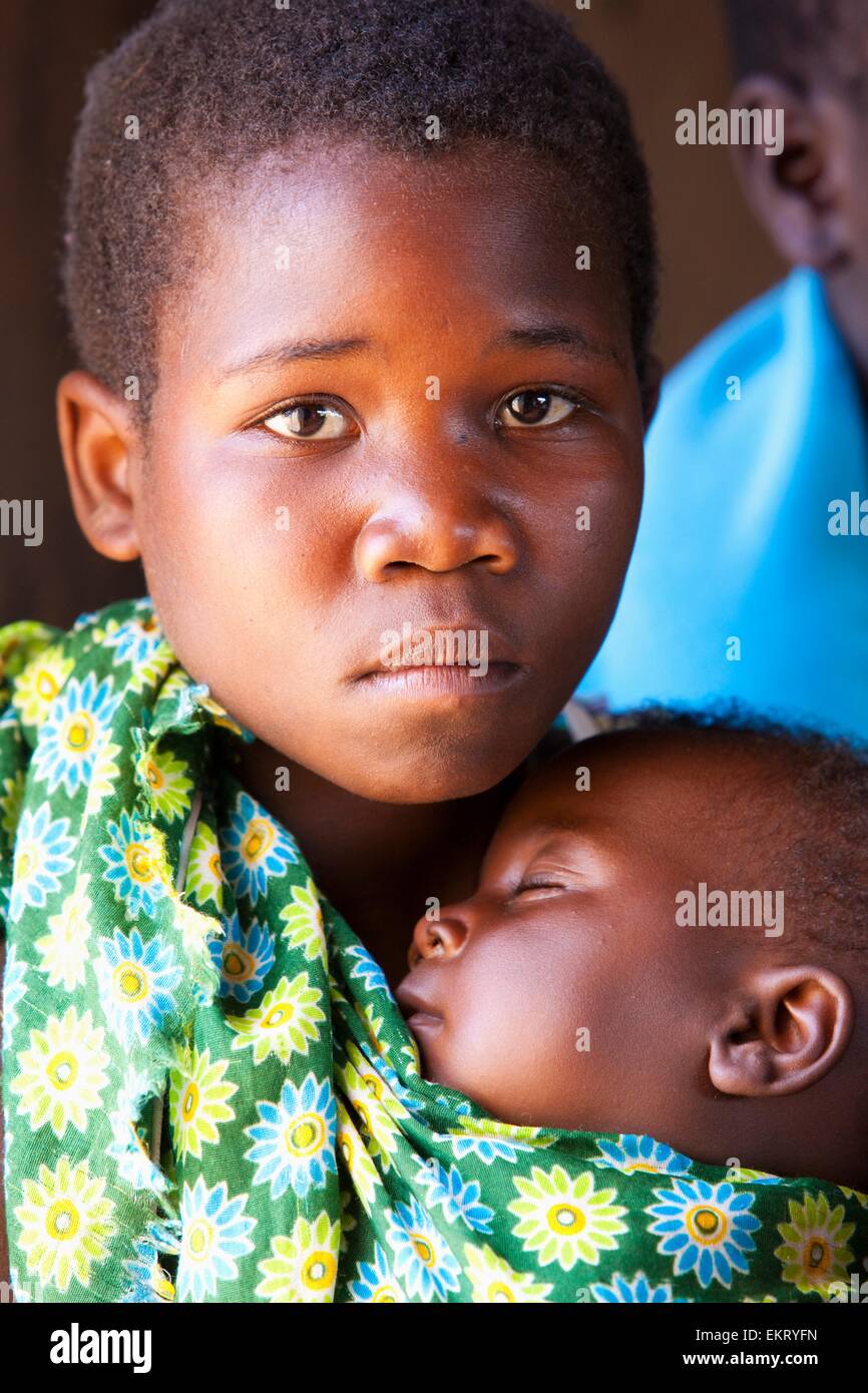 A Girl Carries A Baby In A Sling; Manica, Mozambique, Africa Stock